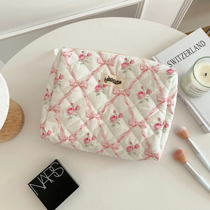 Vue détaillée de la trousse de maquillage matelassée avec imprimés roses et fermeture éclair