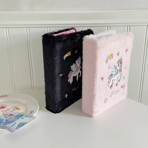 Detail of plush unicorn A5 photocard binders in pink and black with soft faux fur texture
