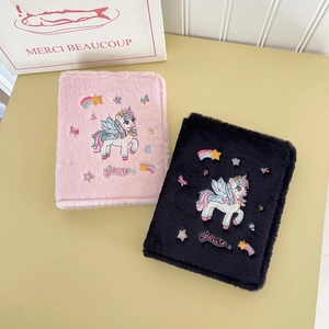 Detail of plush unicorn photo albums in pink and black colors with soft faux fur texture