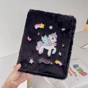 Close-up of black plush unicorn photo album cover with colorful embroidery and star details