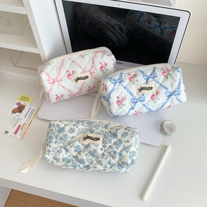 Detail of floral quilted pencil cases with cute ribbons and high-quality fabric texture