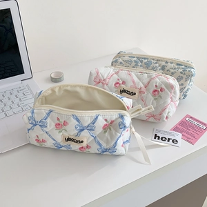 Detailed macro view of quilted cotton pouches featuring floral and bow knot patterns