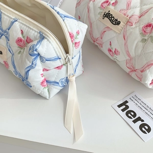 Detail of quilted floral pencil case with pink roses and blue ribbon patterns