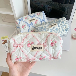Detail of soft quilted floral pencil case with ribbon bow and secure zipper closure