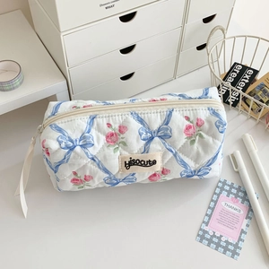 Detailed shot of quilted floral pencil case with pink roses and ribbon zipper puller