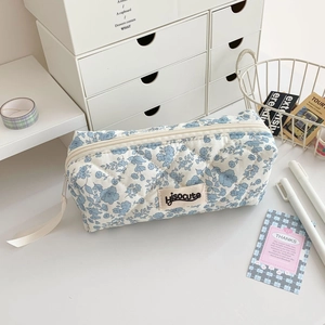 Detail of blue floral quilted pencil case with white zipper and hisocute brand label