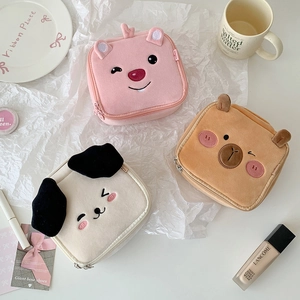 Detailed close-up of cute cartoon plush cosmetic bags in pink, brown and white colors