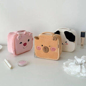 Close-up of cute plush puppy makeup bags in pink and brown with soft fabric texture