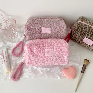 Macro detail of plush leopard print cosmetic bags with soft handles and zipper closures