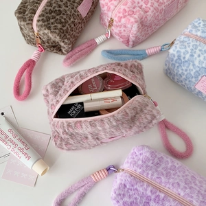Plush leopard print makeup bags in various colors with soft faux fur and wristlet strap