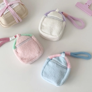 Detailed view of plush mini house doll pouches with colorful straps and zippers