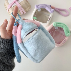 Close-up of a blue and pink plush house-shaped doll carrier bag with a sturdy carabiner