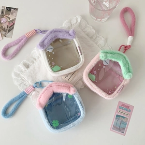 Detail view of plush house-shaped doll bags with clear windows and woven straps