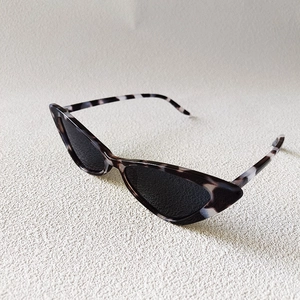 Close-up of cat-eye sunglasses featuring tortoise shell marble texture and dark lenses