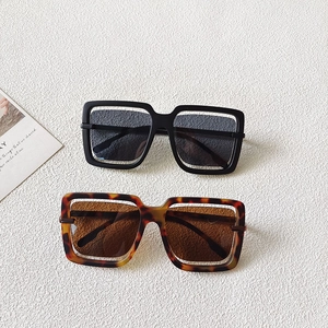 Close-up of oversized hollow square sunglasses in classic black and tortoise finishes