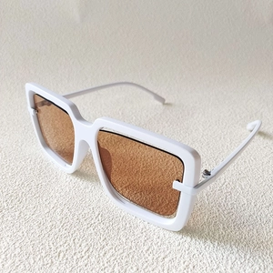 Detailed top view of oversized white square frame sunglasses with amber lenses and bold temples