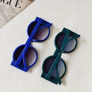 Detail of retro oversized round sunglasses with blue and green frames and gradient lenses