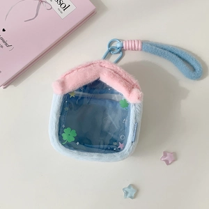 Close-up of plush house-shaped doll display bag with clear PVC window and blue hook