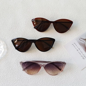 Detailed flat lay of cat eye glasses in black, tortoiseshell and purple on textured surface