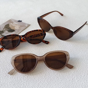 Three retro cat-eye sunglasses in leopard and solid brown styles on white textured background