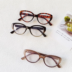 Retro cat-eye eyewear frames in tortoiseshell and gradient styles on white leather
