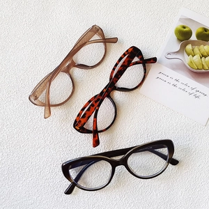 Detailed close-up of retro cat-eye frames in transparent tea, tortoiseshell and black