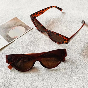 Lunettes de soleil œil de chat rétro avec montures écaillées et brunes sur fond blanc