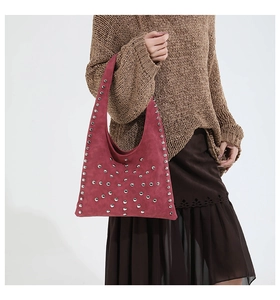 Détail du sac hobo bordeaux en daim avec rivets argentés et texture mate élégante