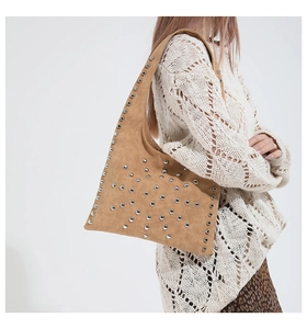 Close-up of suede tote bag with silver rivets and bohemian motorcycle style details