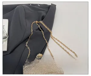 Détail de la bandoulière chaîne dorée et du tissu champagne avec boucle en strass