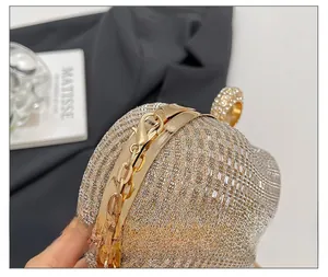 Détail d'une pochette de soirée avec texture tissée et fermoir anneau en strass et chaîne
