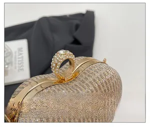Vue détaillée d'une pochette de soirée en paillettes dorées avec fermoir bague en diamants