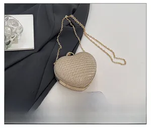 Détail de la pochette coeur champagne doré avec strass et chaîne en métal