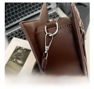 Detailed close-up of the silver metal hook and D-ring on the brown leather tote bag