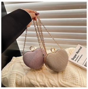 Détail de pochettes en forme de cœur avec paillettes scintillantes et chaîne dorée