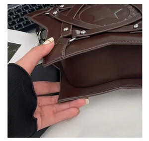 Detailed view of precision stitching and silver rivets on a dark brown star-shaped bag
