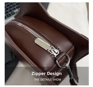 Detail of silver metal zipper closure and D-ring on brown leather tote bag