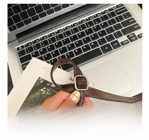 Detail of adjustable leather shoulder strap with silver buckle and neat stitching