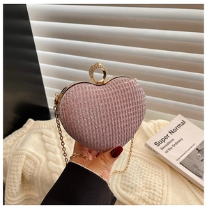 Détail de la pochette de soirée rose pailletée en forme de cœur avec anneau doré
