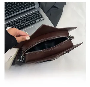 Top view of star-shaped crossbody bag interior with silver zipper and dark brown lining