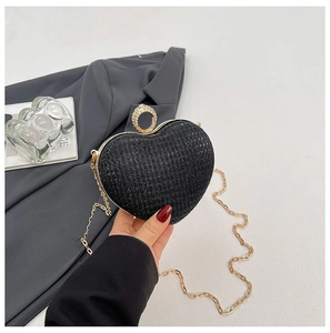 Gros plan d'une pochette cœur noire scintillante avec fermoir doré en strass