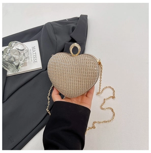 Détail du sac de soirée en forme de cœur doré champagne avec paillettes et fermoir diamant