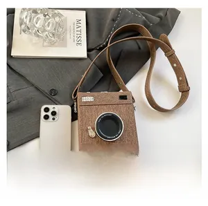 Close-up of vintage camera-style shoulder bag in brown tweed with leather strap