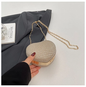 Détail du sac de soirée en forme de cœur en strass doré avec sa chaîne métallique