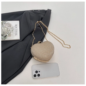 Détail d'une pochette en forme de cœur couleur champagne doré avec paillettes et chaîne