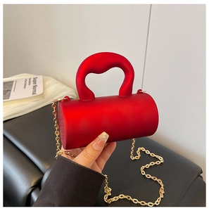 Vue détaillée du mini sac cylindrique rouge givré avec une fine chaîne dorée élégante