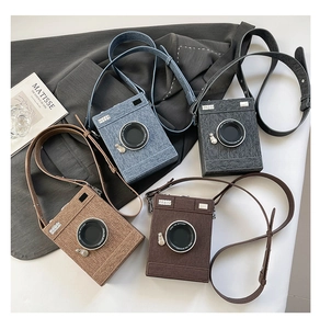 Flat lay of camera-shaped crossbody bags in denim blue, gray, khaki, and dark brown colors
