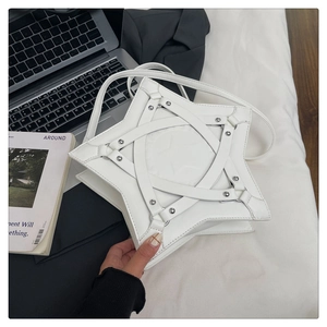 Close-up of white star-shaped shoulder bag with metallic studs and cross-strap details