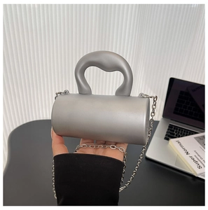 Détail du mini sac de soirée cylindrique gris argenté avec finition mate et chaîne