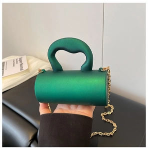 Détail du mini sac cylindrique vert métallisé avec poignée épaisse et bandoulière chaîne